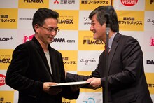 イ・ヨンガン（右）から最優秀作品賞の賞状を受け取るペマ・ツェテン（左）。