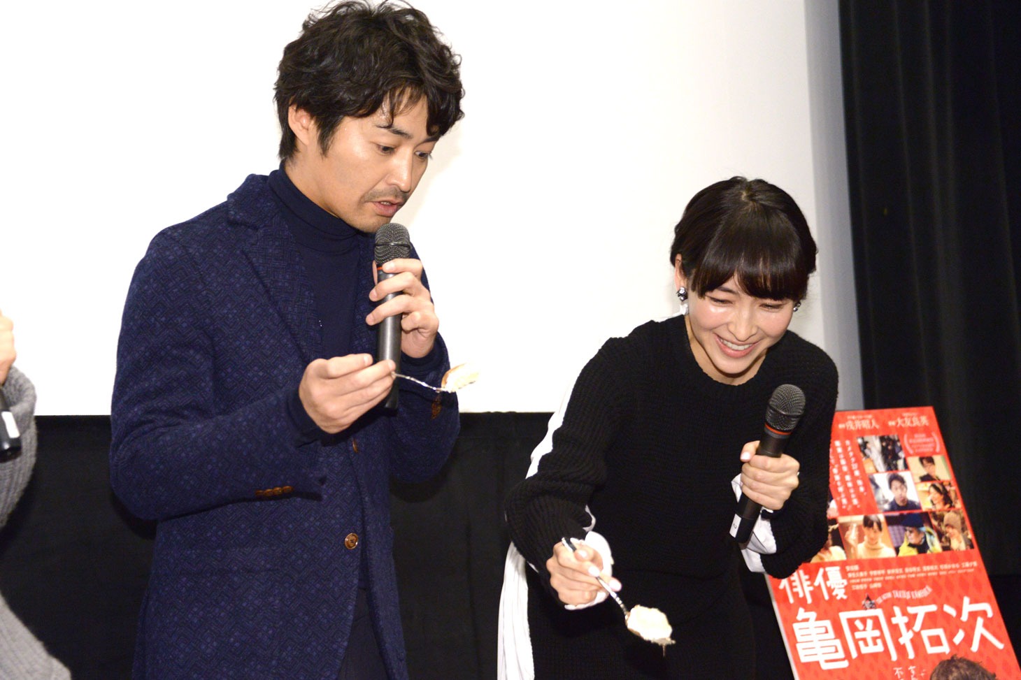 安田顕の顔がデザインされたケーキの、目の部分を笑顔でくり抜く麻生久美子（右）。