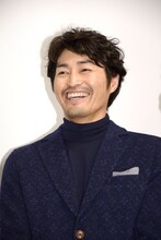 カメラマンからの「おめでとうございます！」の声に笑顔を見せる安田顕。