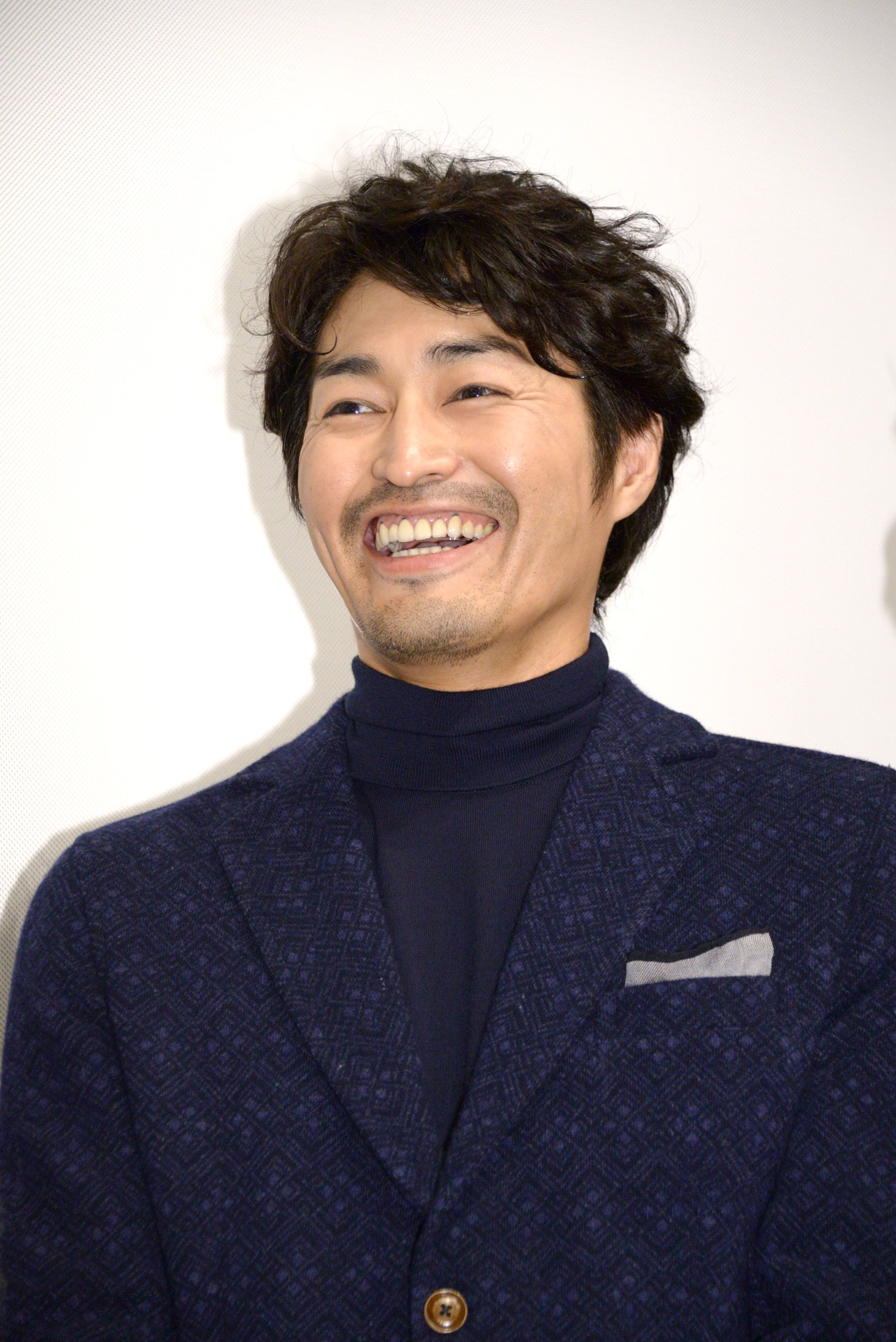 カメラマンからの「おめでとうございます！」の声に笑顔を見せる安田顕。