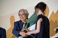 黒木華（右）から花束を受け取った山田洋次（左）。