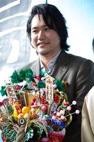 三遊亭小遊三から贈られた熊手を持つ松山ケンイチ。