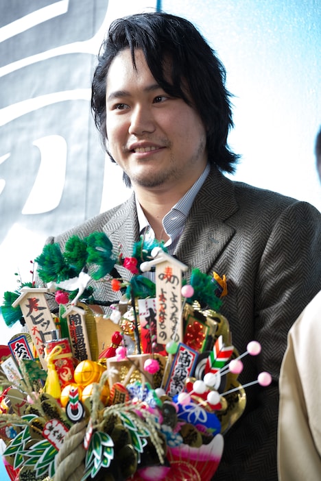 三遊亭小遊三から贈られた熊手を持つ松山ケンイチ。