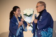 石橋冠（右）に花束を渡す優香（左）。