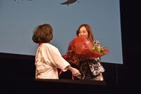 恐る恐る石井心愛（左）から花束を受け取った板野友美（右）。