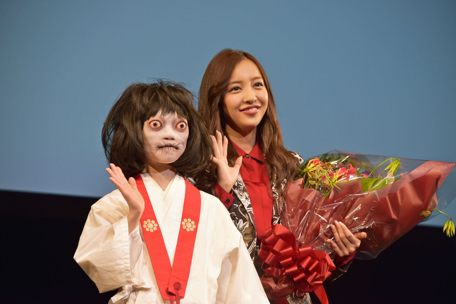 手を振る“のぞきめ”（左）と板野友美。