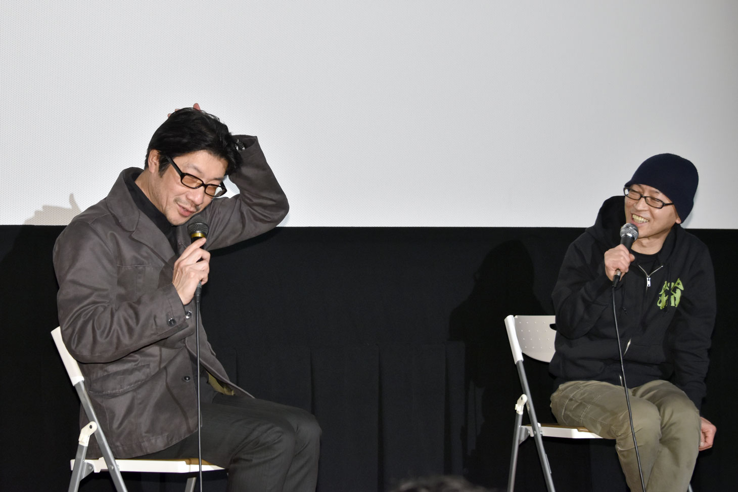ザ・スターリンがライブで客席に投げ込んだ、豚の頭部について説明する阪本順治（左）。