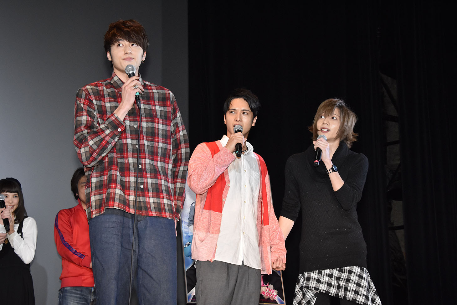 手をつなぐ染谷俊之（右）と中村優一（中央）。