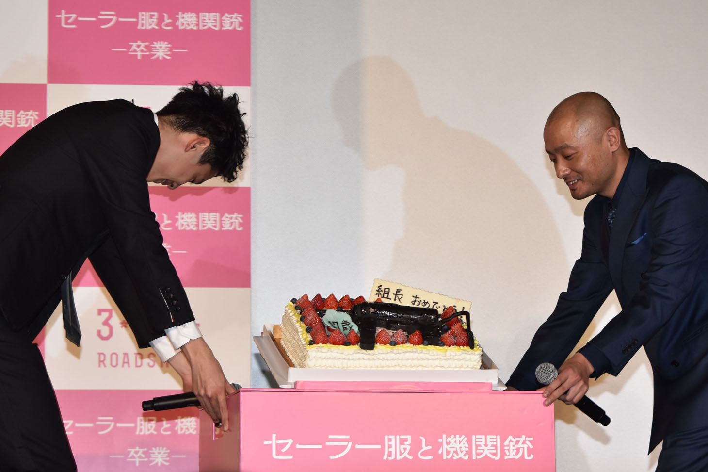 ケーキを運ぶ大野拓朗（左）と宇野祥平（右）。