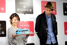 ロマンスカー型チョコレートケーキを手にする大島優子（左）と、鮮やかなブルーに微妙な表情を浮かべる大倉孝二（右）。