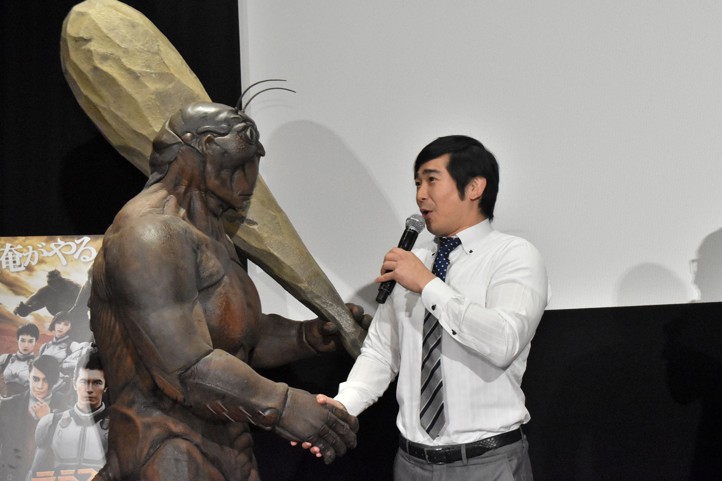 着ぐるみのテラフォーマーと握手を交わすハマカーンの浜谷健司（右）。