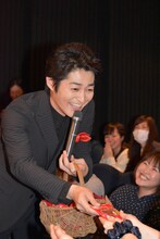 ばっちりとポーズを決めながらチョコレートを配る安田顕。