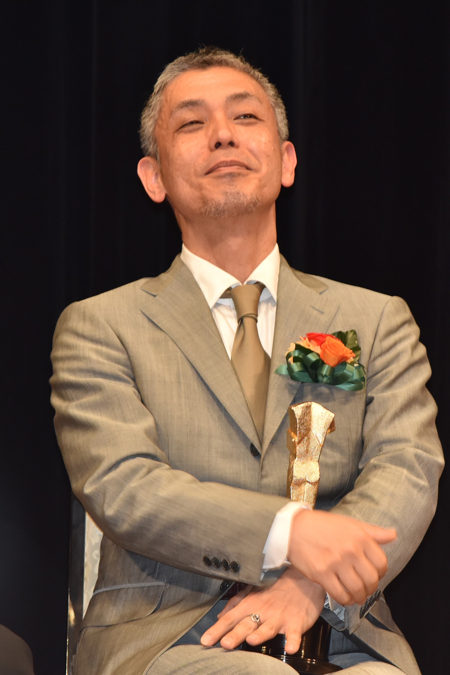 スピーチ中の篠原篤を見守ろる橋口亮輔。