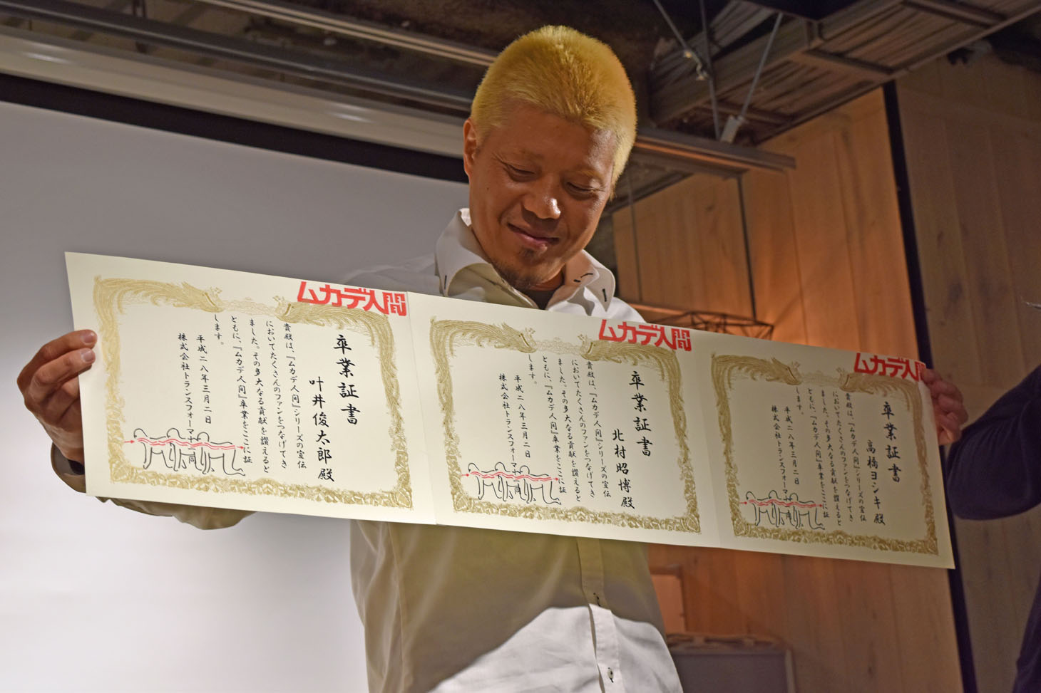 “ムカデ人間卒業証書”を受け取った北村昭博。