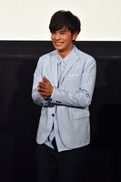 スカーフを巻き終わり、照れる北村匠海。