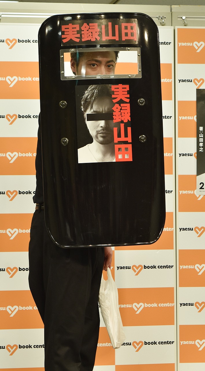 「実録山田」発売記念会見より、防弾盾を構えて登場した山田孝之。