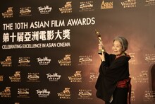 第10回アジア・フィルム・アワードで特別功労賞を受賞し、トロフィーを掲げる樹木希林。