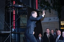 来場者との交流を終え、手を振るレオナルド・ディカプリオ。