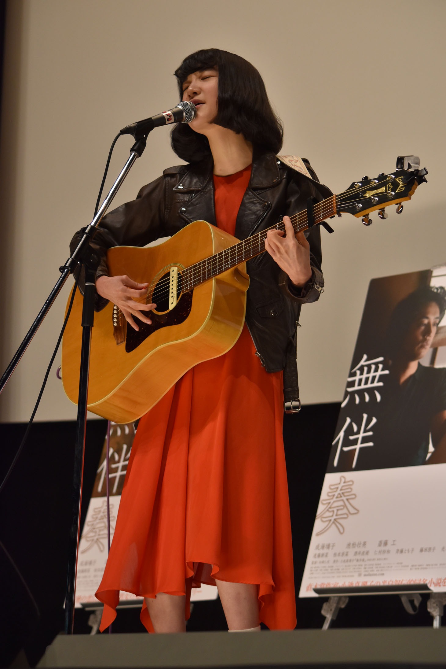主題歌「どこかへ」を弾き語る中野ミホ。