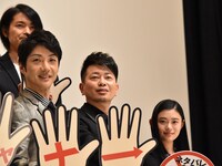 「スキャナー 記憶のカケラをよむ男」完成披露舞台挨拶より、手持ち看板を持ってのフォトセッション。左手前から野村萬斎、宮迫博之、杉咲花。左奥は古沢良太。