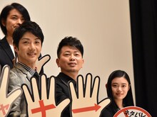 「スキャナー 記憶のカケラをよむ男」完成披露舞台挨拶より、手持ち看板を持ってのフォトセッション。左手前から野村萬斎、宮迫博之、杉咲花。左奥は古沢良太。