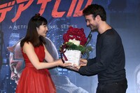 チャーリー・コックス（右）にデアデビルのマスクを模したフラワーアレンジメントを渡す武田梨奈（左）。