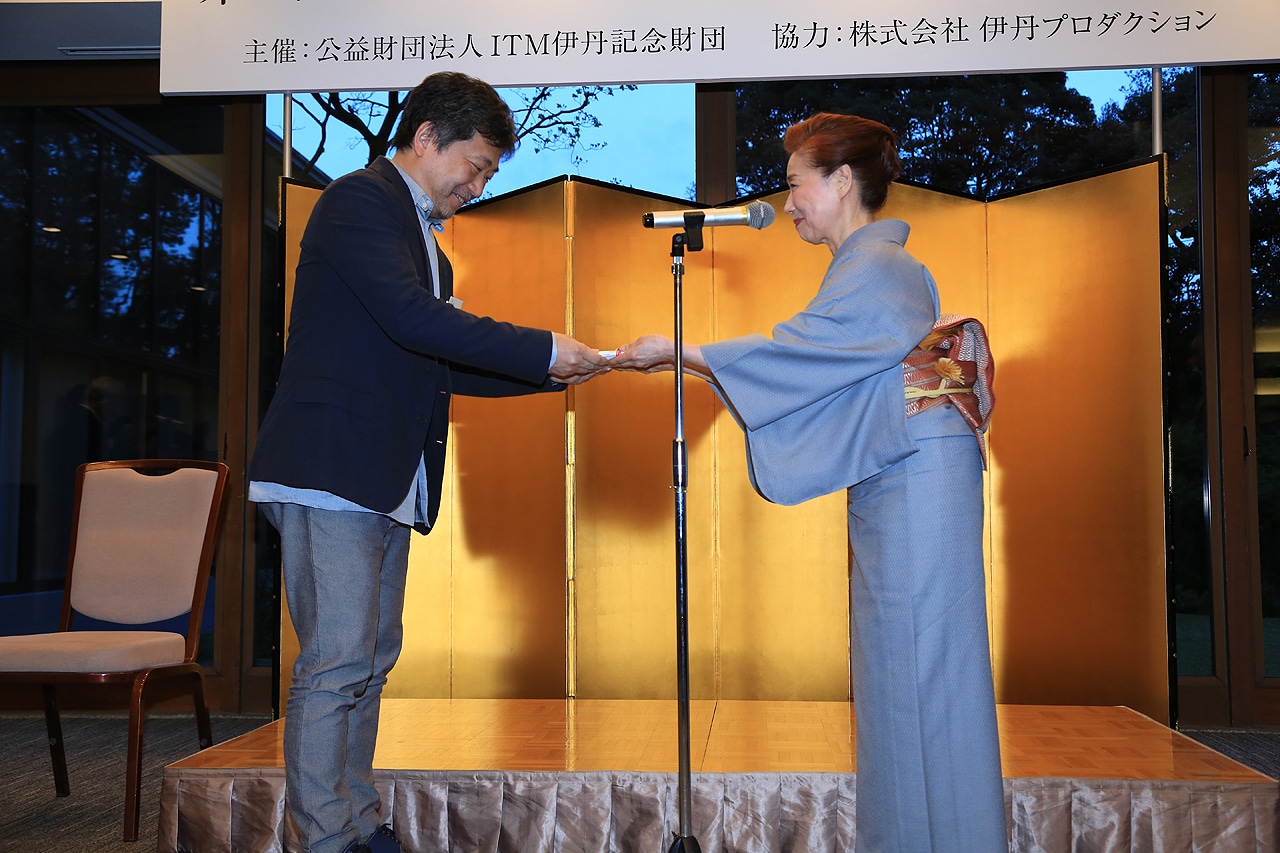 宮本信子（右）から賞金を受け取る是枝裕和（左）。