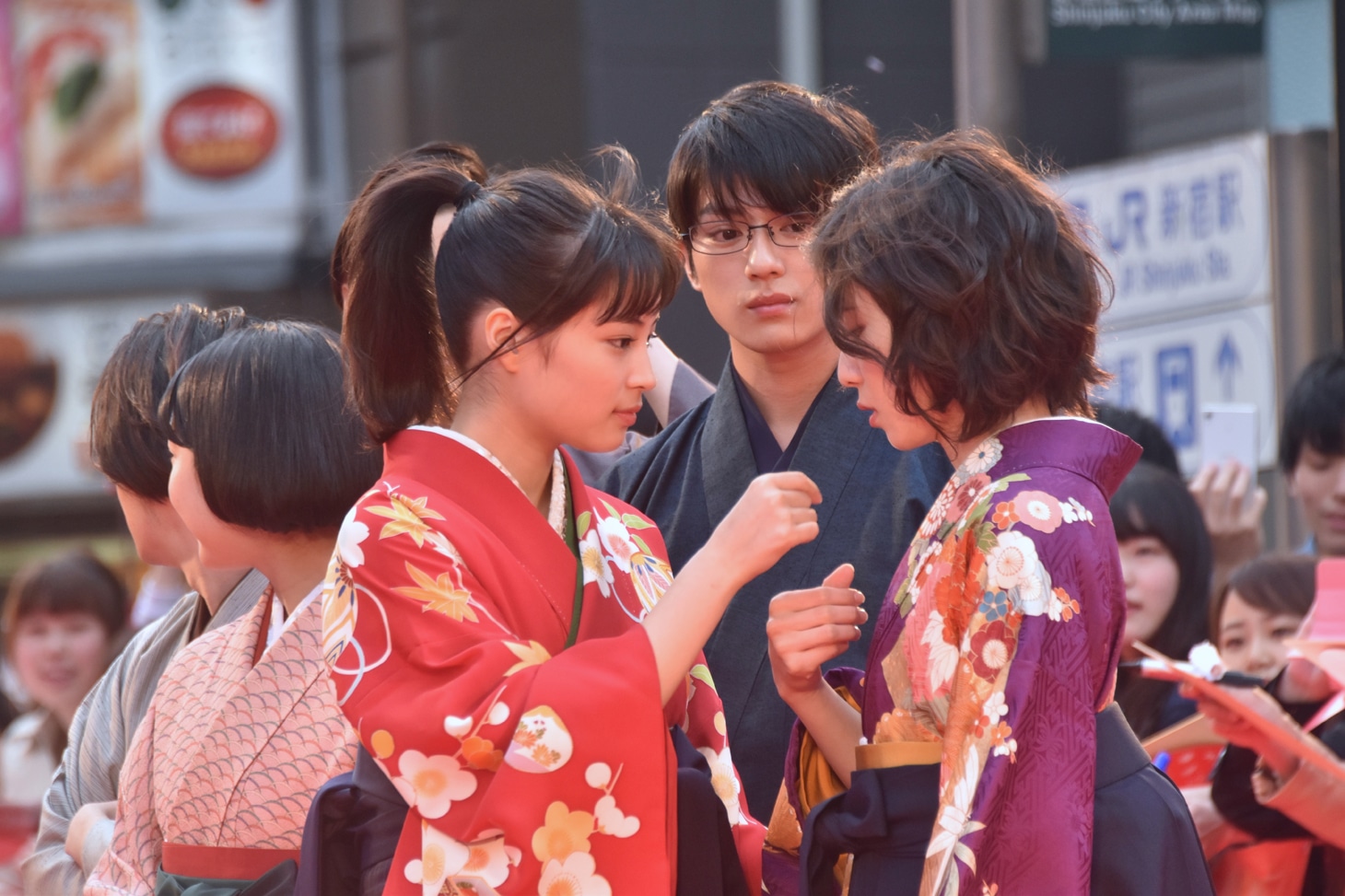 松岡茉優（右）の顔に付いた紙吹雪を取る広瀬すず（左）。