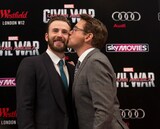 「シビル・ウォー／キャプテン・アメリカ」UKプレミアにて、クリス・エヴァンス（左）の頬にキスするロバート・ダウニー・Jr.（右）。