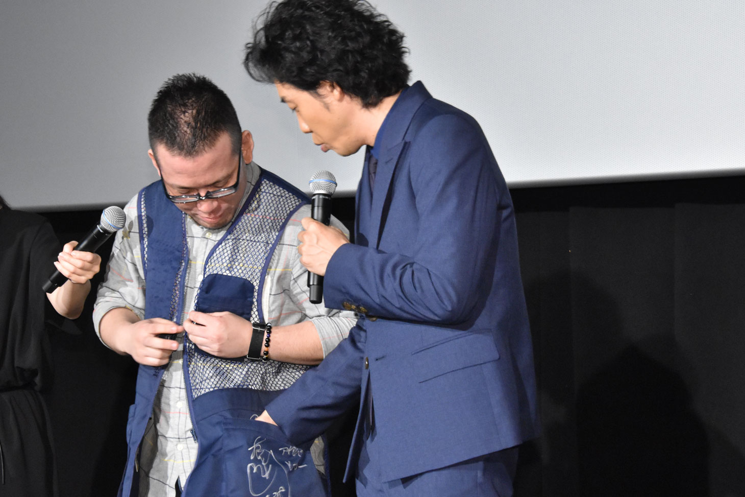“ベスト・オブ・アイアムアヒーローファン”に選ばれた観客にベストを進呈する大泉洋（右）。