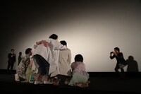 客席をバックに、小泉徳宏に記念撮影をしてもらうキャスト陣。