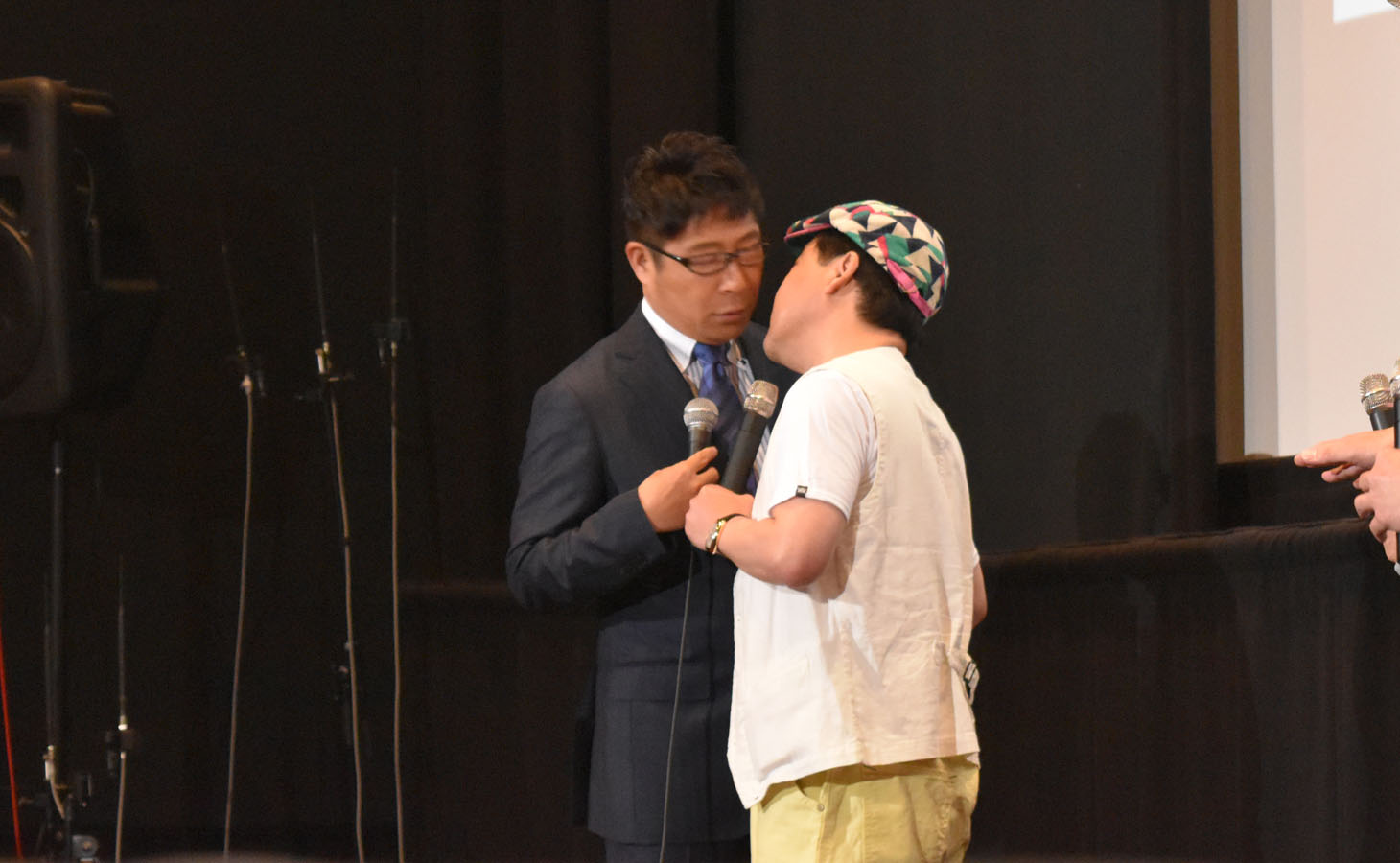 司会の辻よしなり（左）にキスする上島竜兵（右）。