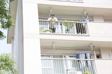 良多の母・淑子が住む団地として描かれた、旭が丘団地。ベランダから下を見下ろす、阿部寛演じる良多。