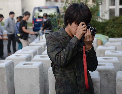 「復讐したい」初回限定版DVD封入のブックレットより、カメラ撮影する平松賢人。