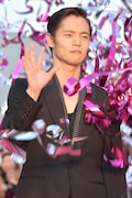 突然飛び出したピンク色のテープに驚きながらも、表情を崩さず手を振る窪田正孝。