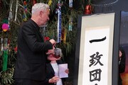 掛け軸状の短冊に「一」を書き入れたローランド・エメリッヒ。