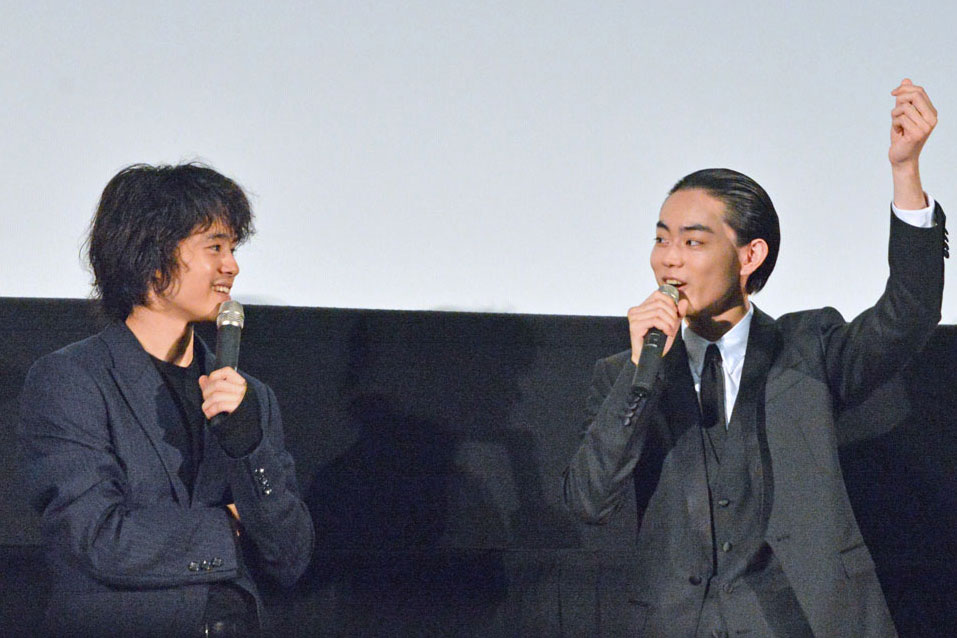 撮影現場に見学に来た祖父が、お小遣いの2万円を掲げる姿を再現する菅田将暉（中央）。