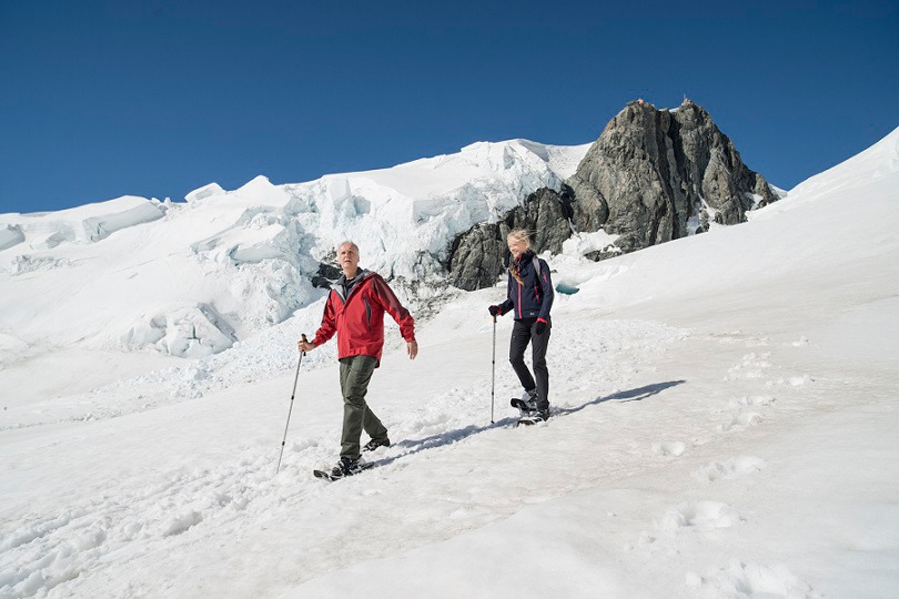タスマン氷河に積もった雪の傾斜面を歩くジェームズ・キャメロン（左）とスージー・エイミス（右）。