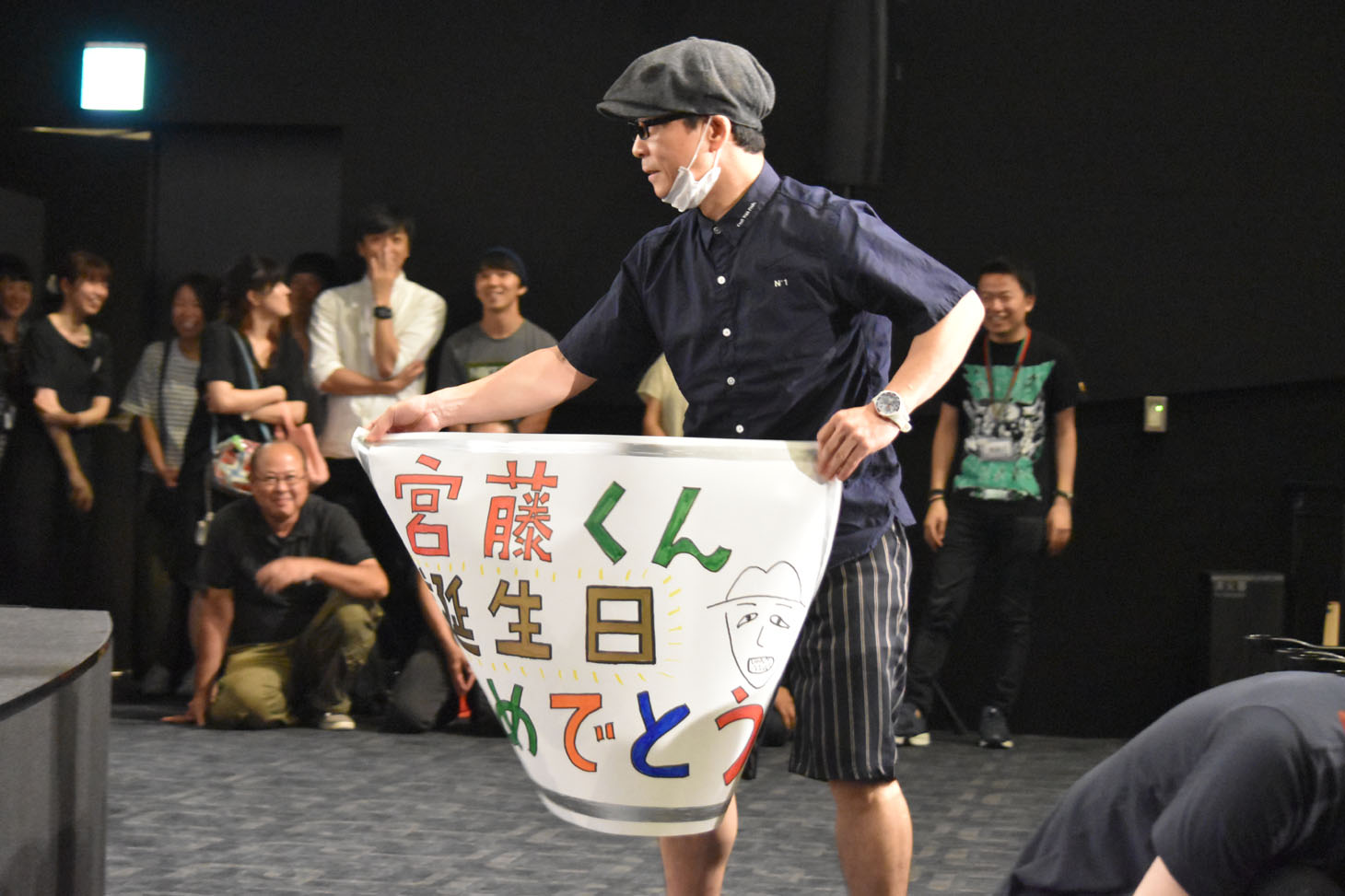 メッセージの書かれた紙を宮藤に渡すと、静かに席に戻った三宅弘城。