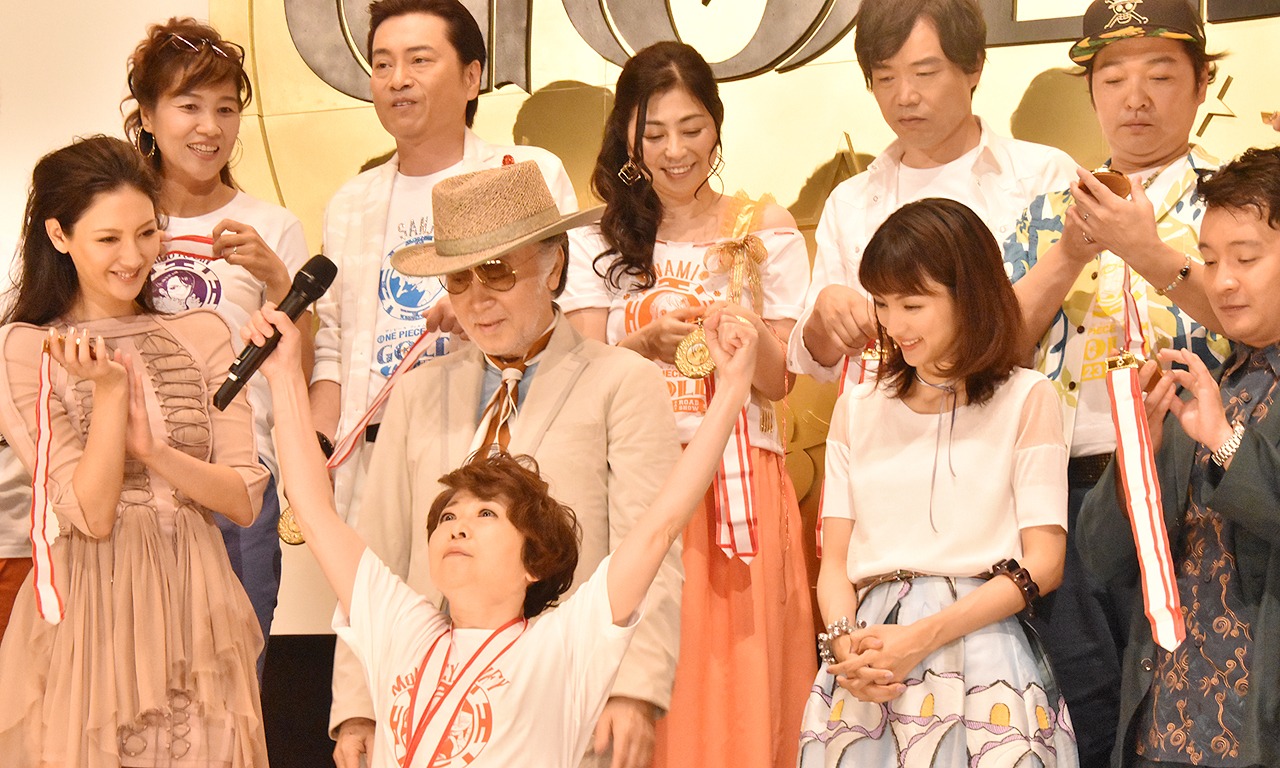 「ONE PIECE FILM GOLD」初日舞台挨拶より、ゴールドメダルを自慢気に見せ喜ぶ田中真弓（中央）。