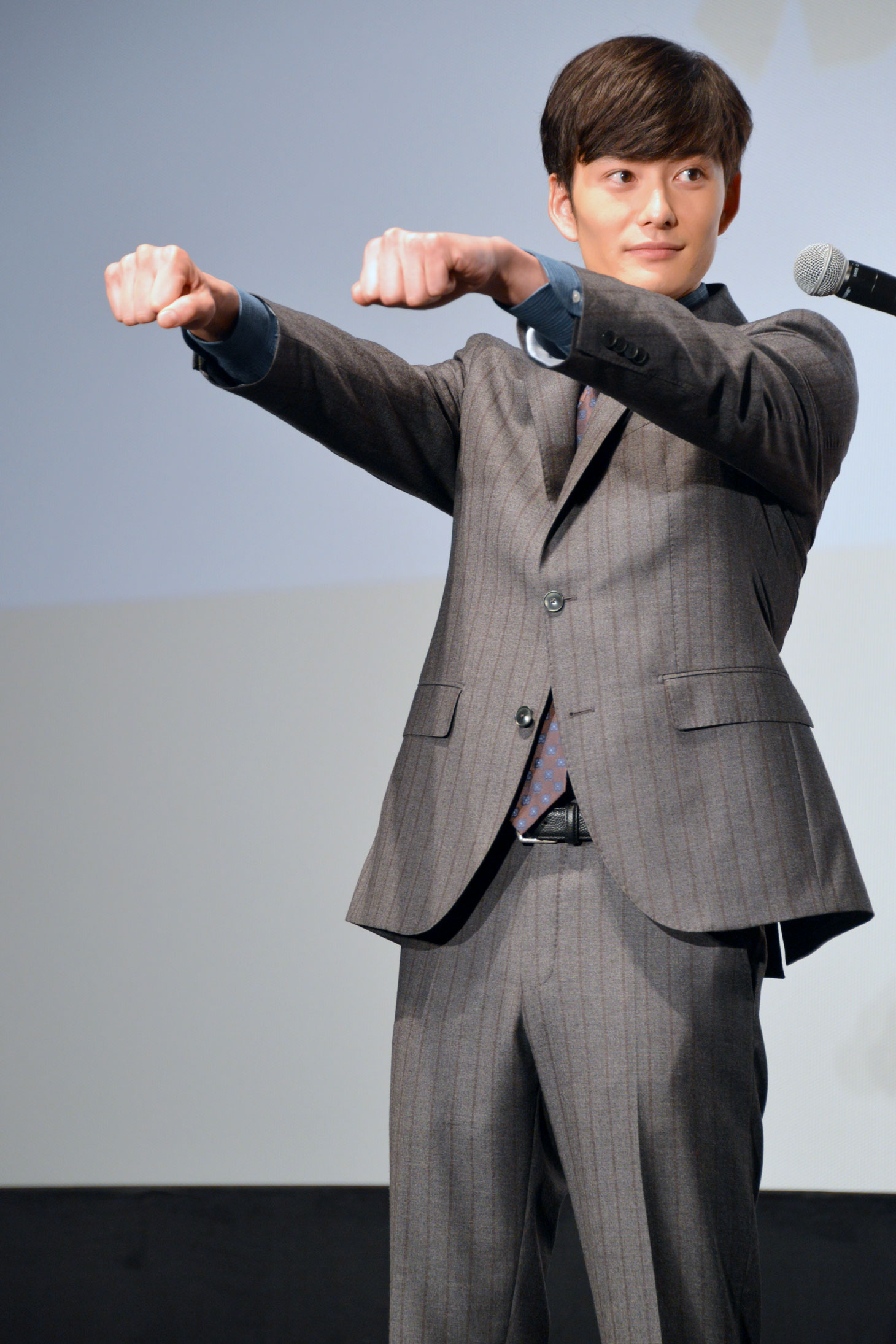 ドミノをどちらの手に隠したか当てるゲームで、トニー・ジャンの指示に従って手を突き出す岡田将生。
