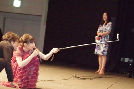 自撮り棒を使い、ファンと記念撮影を行う様子。