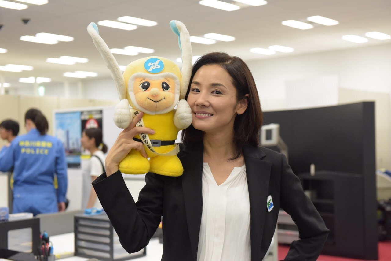 連続ドラマW「コールドケース ～真実の扉～」公式Instagramより、神奈川県警のマスコット“ピーガルくん”の人形を抱えた吉田羊。
