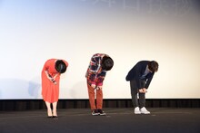 客席に向けて深々と頭をさげる登壇者たち。左から上白石萌音、神木隆之介、新海誠。