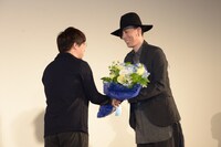 RADWIMPSボーカル・野田洋次郎（右）から花束を受け取る新海誠（左）。