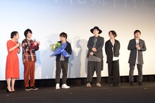 RADWIMPS（右3人）から花束を受け取った新海誠（中央）と、恐縮しすぎてどんどん後ずさっていく神木隆之介（左から2番目）、上白石萌音（左端）。