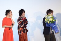 RADWIMPSから花束を受け取った新海誠（右）と、恐縮しすぎてどんどん後ずさっていく神木隆之介（左から2番目）、上白石萌音（左端）。
