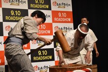 超高速餅つきにチャレンジする佐々木蔵之介（左）。