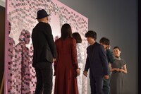 ボードにメッセージを書き込むキャストたち。