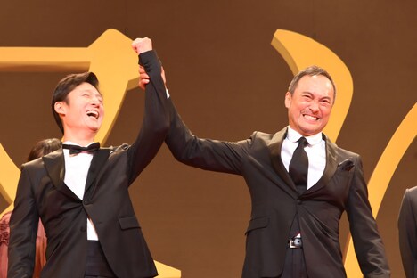 「怒り」ジャパンプレミアより、観客に向かって李相日（左）の手を掲げる渡辺謙（右）。